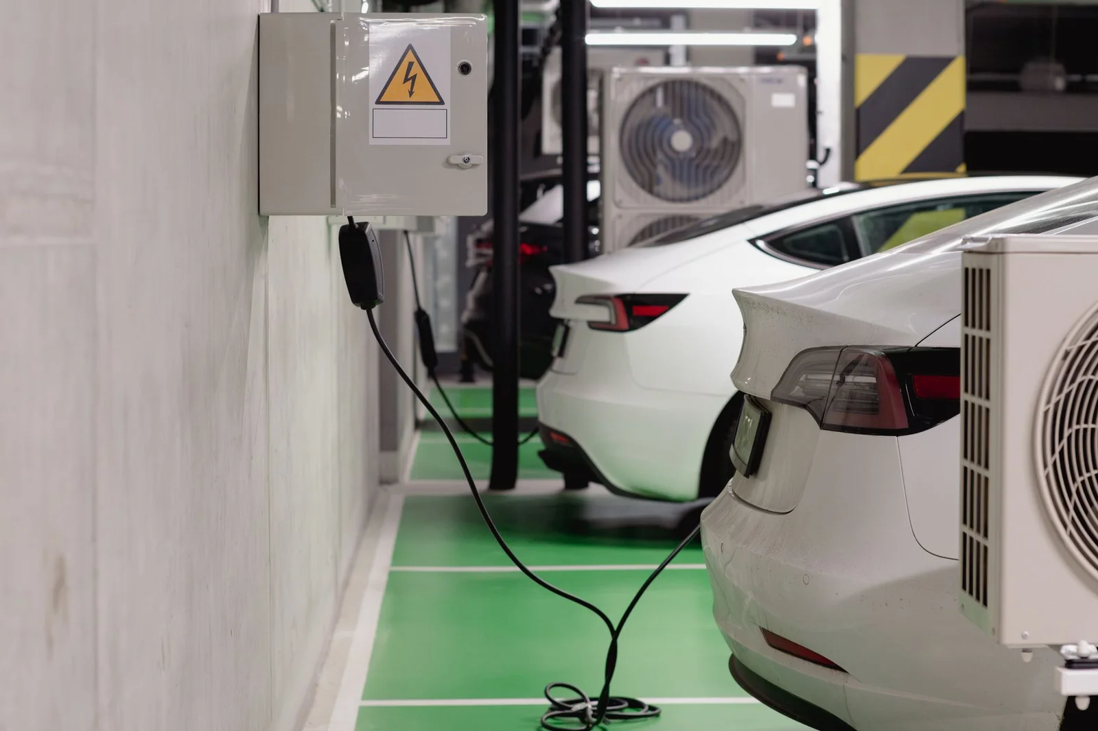 Borne de recharge électrique installée dans un parking en sous-sol, lumière douce