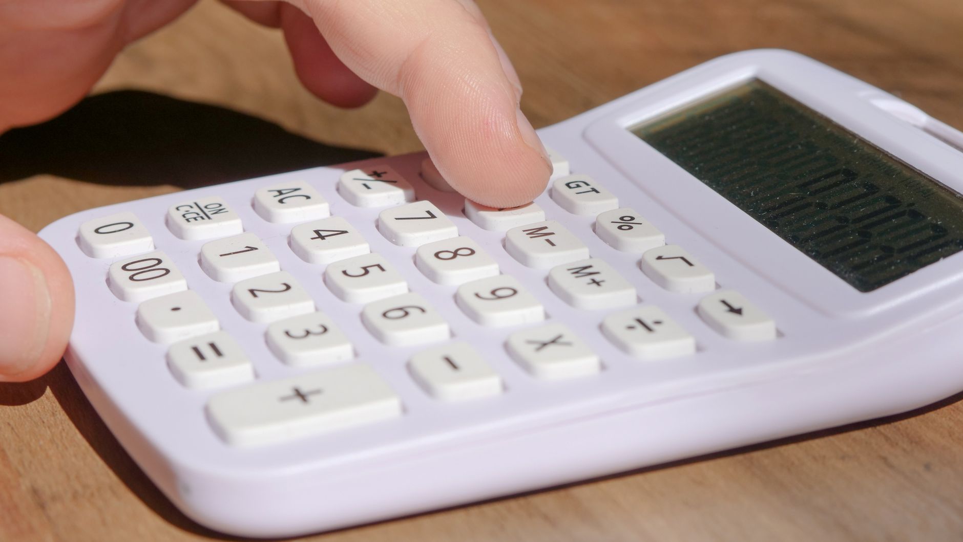 Calculatrice et clés de parking sur un bureau épuré